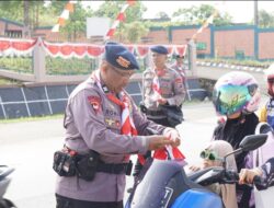 Brimob Polda Kalsel Batalyon B Pelopor Bagikan Ratusan  Bendera Merah Putih kepada Pengguna Jalan Di Tanah Bumbu.